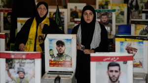 Relatives visit the graves of killed Hezbollah fighters, at the al-Hawra Zeinab cemetery in a southern suburb of Beirut, Lebanon, Saturday, Sept. 7, 2024. (AP Photo/Bilal Hussein) 