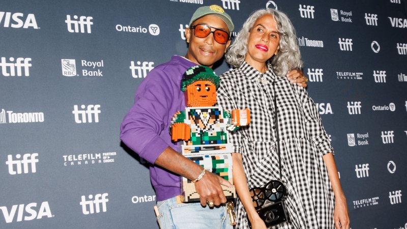 Pharrell Williams and Mimi Valdes arrive on the red carpet for the premiere of 'Piece by Piece' at the Princess of Wales Theatre during the Toronto International Film Festival, in Toronto, Tuesday, Sept. 10, 2024. (THE CANADIAN PRESS/Cole Burston)