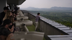 Tourists use binoculars to view North Korea from the Dora Observation Post in the Demilitarized Zone (DMZ) in Paju, South Korea, Saturday, May 25, 2024. (AP Photo/Jae C. Hong)