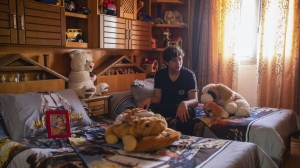 Ahmed Hamadneh, 15, sits on his bed in the bedroom he shared with his twin brother Mahmoud, in Jenin, West Bank, Wednesday, June 5, 2024. Witnesses said Mahmoud was killed by an Israeli sniper on his way home from school. (AP Photo/Bram Janssen)