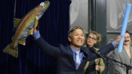 Professor James Liao displays a stuffed fish while accepting a prize for physics for demonstrating and explaining the swimming abilities of a dead trout during a performance at the Ig Nobel Prize ceremony at Massachusetts Institute of Technology in Cambridge, Mass., Thursday, Sept. 12, 2024. (AP Photo/Steven Senne)