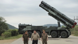 In this undated photo provided on Friday, Sept. 13, 2024, by the North Korean government, its leader Kim Jong Un, center, walks with other officials near what it says is their new launch vehicle of 600mm multiple rockets at an undisclosed location in North Korea. The content of this image is as provided and cannot be independently verified. . (Korean Central News Agency/Korea News Service via AP)