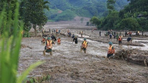 Rescue workers search for the missing after a flash flood buries a hamlet in mud and debris in the aftermath of Typhoon Yagi in Lao Cai province, Vietnam Thursday, Sept. 12, 2024. (Duong Van Giang/VNA via AP)