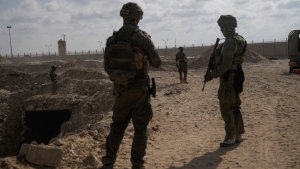 Israeli soldiers take up positions next to an entrance of a tunnel which the military says Hamas militants used in the southern Gaza Strip, about a 100 meters from the Philadelphi Corridor along the border with Egypt, during a ground operation on Friday, Sept. 13, 2024. (AP Photo/Leo Correa) 