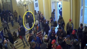 This image from video from the Justice Department in the statement of facts supporting an arrest warrant, and annotated by the source, shows Kevin Alstrup, circled in yellow, a U.S. State Department diplomatic security officer, entering the U.S. Capitol on Jan. 6, 2021, in Washington. (Justice Department via AP)