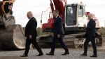 Ontario Premier Doug Ford, Umicore CEO Mathias Miedreich and Innovation and Science and Industry Minister Francois-Philippe Champagne make their way past heavy equipment to a ceremonial ground breaking ceremony, in Millhaven, Ont., Monday, Oct. 16, 2023. THE CANADIAN PRESS/Adrian Wyld