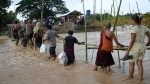 Local residents wade through flooded water at a broken bridge, in Naypyitaw, Myanmar, Tuesday, Sept. 17, 2024. (AP Photo/Aung Shine Oo)
