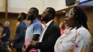 Members of the Haitian community in Springfield, Ohio stand for worship at Central Christian Church, on Sept. 15, 2024. (AP Photo/Jessie Wardarski)