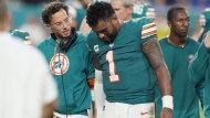 Miami Dolphins head coach Mike McDaniel talks to quarterback Tua Tagovailoa (1) as he leaves the game after suffering a concussion during the second half of an NFL football game against the Buffalo Bills, Thursday, Sept. 12, 2024, in Miami Gardens, Fla. (AP Photo/Rebecca Blackwell)