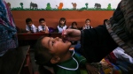 A health worker administers a polio vaccine to a child at a school in Peshawar, Pakistan on Sept. 9, 2024. (Muhammad Sajjad / AP Photo)