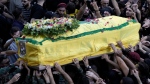 Hezbollah fighters carry one of the coffins of four fallen comrades who were killed Tuesday after their handheld pagers exploded, during their funeral procession in the southern suburb of Beirut, Lebanon, Wednesday, Sept. 18, 2024. (Bilal Hussein / The Associated Press)