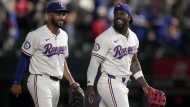 Texas Rangers' Marcus Semien, left, and Adolis Garcia walk off the field after their team's win against the Toronto Blue Jays in a baseball game in Arlington, Texas, Wednesday, Sept. 18, 2024. (AP Photo/Tony Gutierrez)