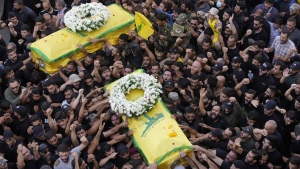 Hezbollah members carry the coffins of two of their comrades who were killed on Wednesday when a handheld device exploded, during a funeral procession in the southern suburbs of Beirut, Thursday, Sept. 19, 2024. (AP Photo/Hussein Malla)