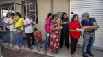 People wait in a queue to cast their votes at a polling center during the presidential election Colombo , Sri Lanka Saturday, Sept. 21, 2024.(AP Photo/Rajesh Kumar Singh)