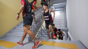 In this photo provided by ISF/Meeting, competitors climb stairs during a race of Stairclimbing World Championships in Osaka, western Japan, on Nov. 19, 2023. (ISF/MEETING via AP)