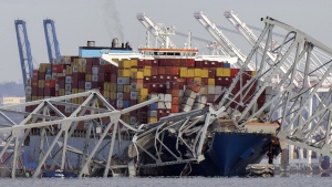 The cargo ship Dali is stuck under part of the structure of the Francis Scott Key Bridge after the ship hit the bridge, Tuesday, March 26, 2024, as seen from Pasadena, Md. (AP Photo/Mark Schiefelbein, File)