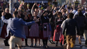 Waitresses film the opening start of the 189th 'Oktoberfest' beer festival in Munich, Germany, Saturday, Sept. 21, 2024. (Matthias Schrader/AP Photo)