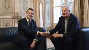 French President Emmanuel Macron, left, shakes hands with then-European Union chief Brexit negotiator Michel Barnier at the Elysee Palace in Paris, Friday, Jan. 31, 2020. (Ludovic Marin/Pool Photo via AP, File)