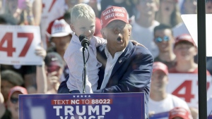 Republican presidential nominee former President Donald Trump holds his grandson Luke Trump as he speaks at a campaign event at Wilmington International Airport in Wilmington, N.C., Saturday, Sept. 21, 2024. (AP Photo/Chris Seward)