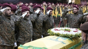 Hezbollah members salute near the coffin of Hezbollah commander Ibrahim Akil during the funeral procession in Beirut's southern suburb, Sunday, Sept. 22, 2024. (AP Photo/Bilal Hussein)