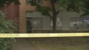 The reflection of a police car is seen in windows behind yellow police tape a day after one person was fatally shot at a complex in Scarborough. 