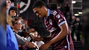 Colorado Rapids defender Reggie Cannon, right, smiles while giving autographs after an MLS soccer match against Toronto FC Saturday, Sept. 21, 2024, in Commerce City, Colo. (AP Photo/Jack Dempsey)