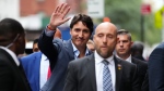 Prime Minister Justin Trudeau, flanked by entourage and security, waves as he arrives to the CBS studios for the filming of "The Late Show with Stephen Colbert," in New York, Monday, Sept. 23, 2024. Trudeau will be interviewed by Colbert, and the episode aired later Monday night. THE CANADIAN PRESS/Sean Kilpatrick