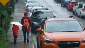 People carry umbrellas while walking during a downpour of rain in Toronto on Tuesday, Sept. 27, 2022. THE CANADIAN PRESS/Alex Lupul