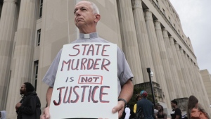 Deacon Dave Billips, with the Office of Peace and Justice with the St. Louis Archdiocese, holds a sign as he stands with protesters holding space to halt the execution of Marcellus Williams on Tuesday, Sept. 24, 2024. (Laurie Skrivan/St. Louis Post-Dispatch via AP)