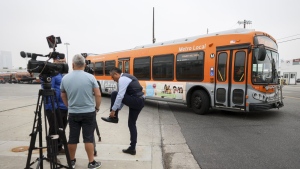 A bus passes by waiting news media in front of a Los Angeles MTA bus depot near the site where overnight a bus was hijacked by an armed subject with passengers on board Wednesday, Sept. 25, 2024. (Ryan Sun/AP Photo)