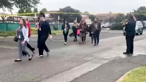 In this still image from video provided by KEYT, people walk past a police barricade following an explosion at the Santa Maria Courthouse in Santa Maria, Calif., Wednesday, Sept. 25, 2024. (KEYT via AP)