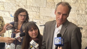 Former University of Wisconsin-La Crosse Chancellor Joe Gow, right, and his wife, Carmen Wilson, center, take questions after a hearing, Friday, Sept. 20, 2024, in Madison, Wis. (AP Photo/Scott Bauer)