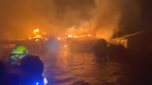 Home burns surrounded by Helene floodwater