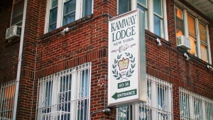 A sign points to the entrance of the Kamway Lodge, Aug. 22, 2019, in the Queens borough of New York. (AP Photo/Eduardo Munoz Alvarez)