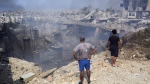 People check a damaged building at the site of an Israeli airstrike in Choueifat, south east of Beirut, Saturday, Sept. 28, 2024. (AP Photo/Hussein Malla)