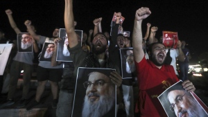 Lebanese and Palestinian men hold portraits of Hezbollah leader Sayyed Hassan Nasrallah in Sidon, Lebanon, on Sept. 28, 2024. (Mohammed Zaatari/AP Photo)