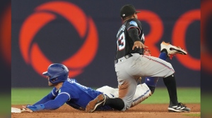 Toronto Blue Jays' George Springer steals second base in front of Miami Marlins shortstop Xavier Edwards during third inning interleague MLB baseball action in Toronto, Saturday, Sept. 28, 2024. THE CANADIAN PRESS/Chris Young