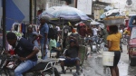 A man rests on a wheelbarrow on a street in Port-au-Prince, Haiti, Monday, Sept. 23, 2024. (AP Photo/Odelyn Joseph)