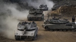 Israeli army tanks manoeuvre in a staging area in northern Israel near the Israel-Lebanon border, Tuesday, Oct. 1, 2024. (AP Photo/Baz Ratner)