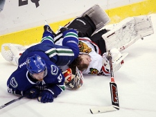 Vancouver Canucks' Henrik Sedin runs over Chicago Blackhawks goaltender Antti Niemi during third period of game 4 NHL western conference playoff hockey action at GM Place in Vancouver, Friday, May 7, 2010. (THE CANADIAN PRESS/Jonathan Hayward)