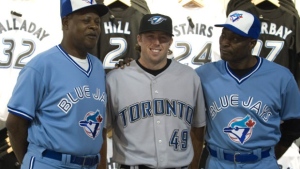 Toronto Blue Jays pitcher Jeremy Accardo, centre, smiles as he listens to former players Lloyd Moseby, right, and John Mayberry talk as they pose during a uniform launch in Toronto. (Adrian Wyld / THE CANADIAN PRESS)