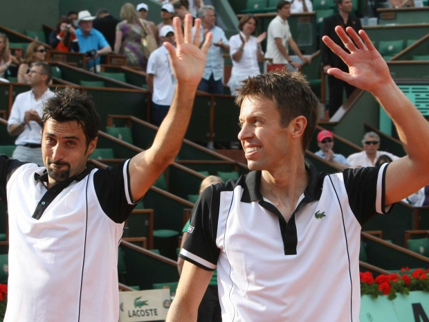 Canada's Daniel Nestor, right, and Serbia's Nenad Zimonjic wave as they defeat Czech Republic's Lukas Dlouhy and India's Leander Paes in the men's doubles final match for the French Open tennis tournament at the Roland Garros stadium in Paris, Saturday, June 5, 2010.(Lionel Cironneau/AP Photo)