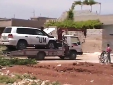 This image made from amateur video released by Shaam News Network and accessed Wednesday, May 16, 2012, purports to show a towed U.N. observer car in Idlib, Khan Sheikhoun, Syria. A team of international observers were evacuated from a tense town in northern Syria a day after their convoy was hit by a roadside bomb, a U.N. spokesman said. (AP Photo/Shaam News Network via AP video)