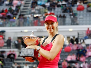 Russia's Maria Sharapova celebrates with the trophy after defeating China's Na Li at the Italian Open tennis finals, in Rome, Sunday, May 20, 2012. Sharapova won 4-6, 6-4, 7-6 (5). (AP Photo/Andrew Medichini)