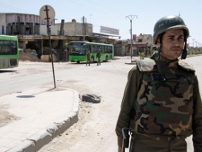 A Syrian government solider stands at a street in the Damascus suburb of Douma, Syria, Sunday, May 20, 2012. A roadside bomb exploded in a restive suburb of the Syrian capital as senior U.N. officials toured the area on Sunday, the latest incident in which the unarmed observer mission has nearly been caught up in the country's bloodshed. (AP Photo/Muzaffar Salman)