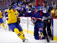 Team Sweden's Petter Granberg, left, knocks Team Slovakia's Tomas Jurco to the ice during first period IIHF World Junior Championships hockey action in Calgary, Alta., on Friday, Dec. 30, 2011. (THE CANADIAN PRESS/Jeff McIntosh)