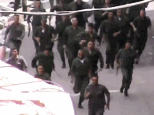 This image made from amateur video released by Shaam News Network and accessed Friday, May 25, 2012 purports to show police running toward a protest in Damascus, Syria. (AP Photo/Shaam News Network via AP video) 