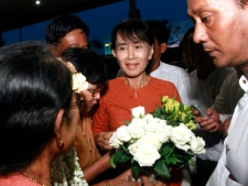 Myanmar opposition leader Aung San Suu Kyi, centre, receives flowers from supporters upon her arrival at Yangon International Airport in Yangon, Myanmar, to leave for Bangkok, Thailand on Tuesday, May 29, 2012, her first trip out of Myanmar in 24 years. (AP Photo/Khin Maung Win)