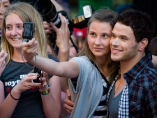 Actor Kellan Lutz (right) poses with fans as he arrives on the red carpet at the MuchMusic Video Awards in Toronto, Sunday June 20, 2010. (THE CANADIAN PRESS/Adrien Veczan)