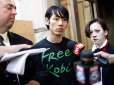 Six-time hot dog-eating contest champion Takeru Kobayashi, center, is joined by his attorney Mario D. Romano, left, and interpreter Maggie James as he speaks to reporters after leaving Brooklyn Criminal Court, Monday, July 5, 2010, in New York. (AP Photo/Mary Altaffer)